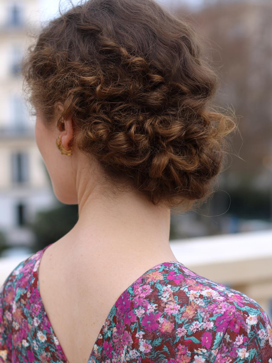 2. Chignon bas soyeux en cheveux bouclés naturellement coiffure avec mèches libres et nuque nette