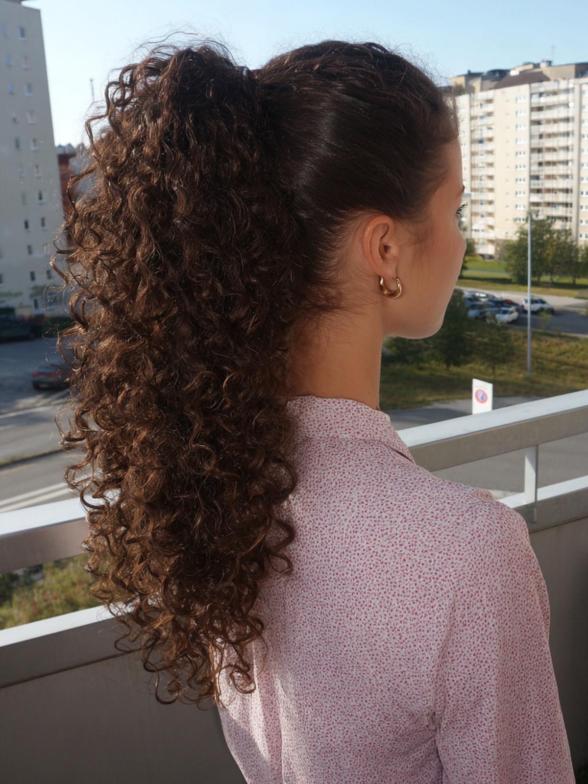 3. Queue de cheval haute en cheveux bouclés naturellement coiffure avec volume au sommet et pointes rebondies