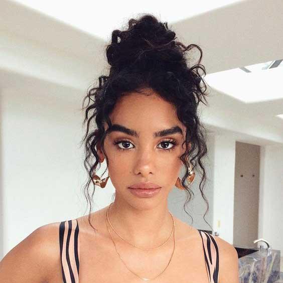 Chignon haut décoiffé cheveux bouclés longs