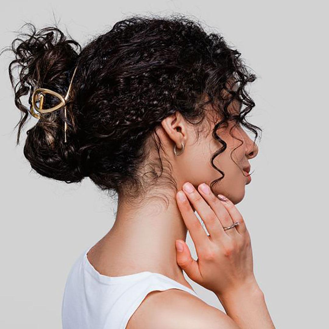 Chignon messy bouclé avec accessoires tendance