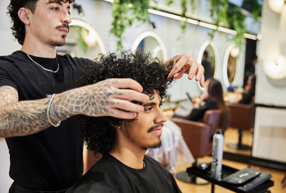 Coiffeur travaillant cheveux bouclés homme