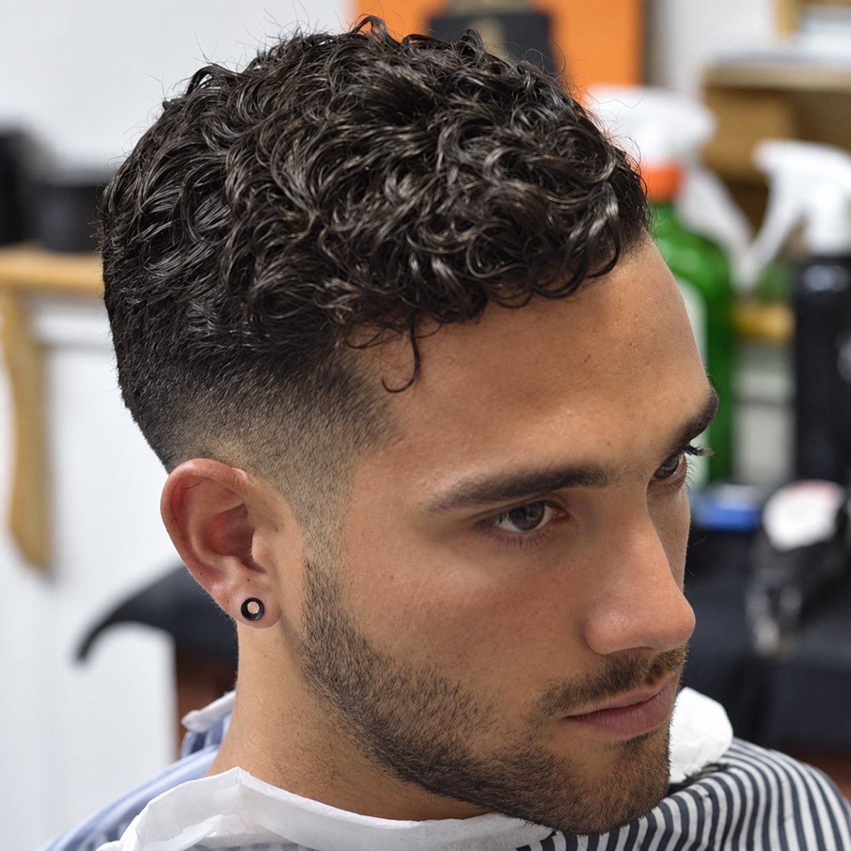 Homme avec coupe courte et cheveux bouclés