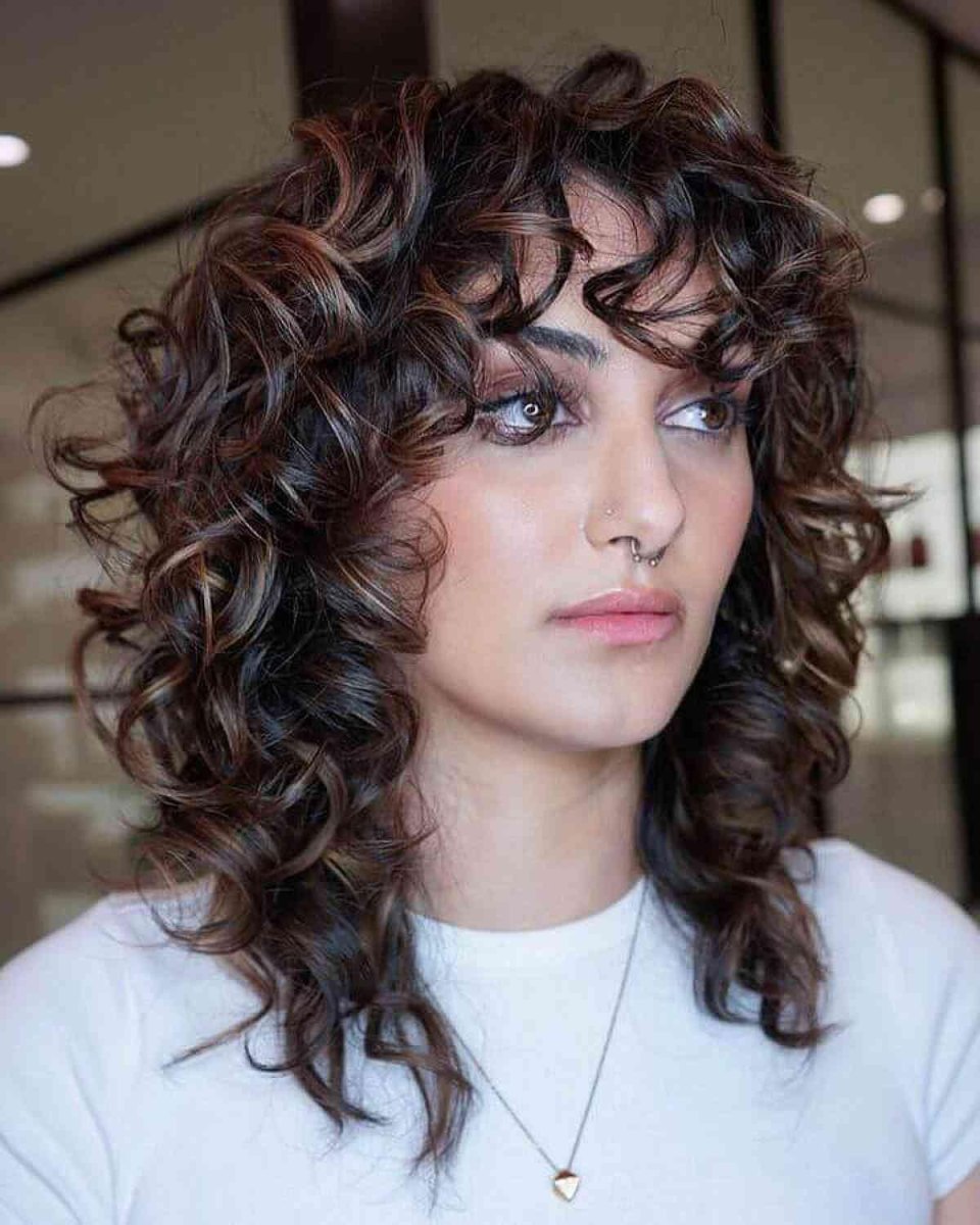 Coupe shag cheveux bouclés mi longs