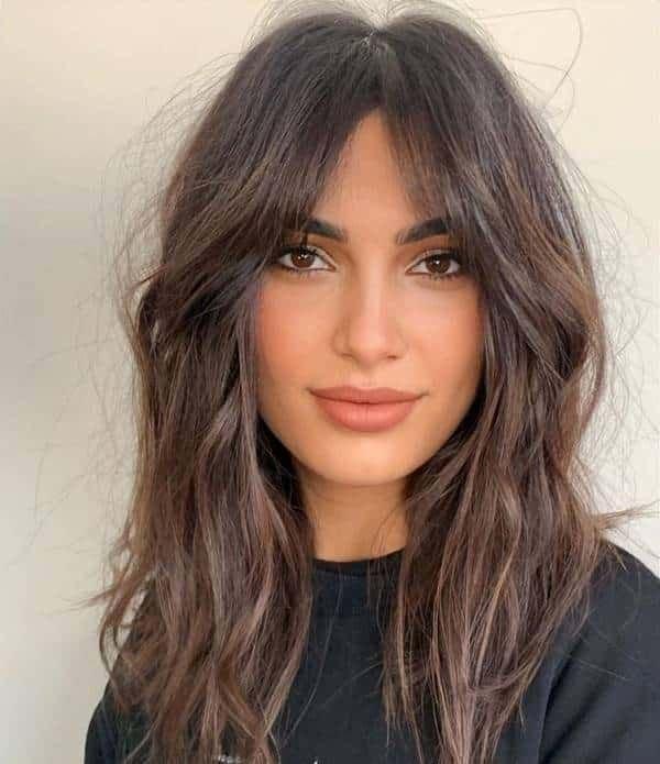 Visage ovale coupe dégradée frange rideau