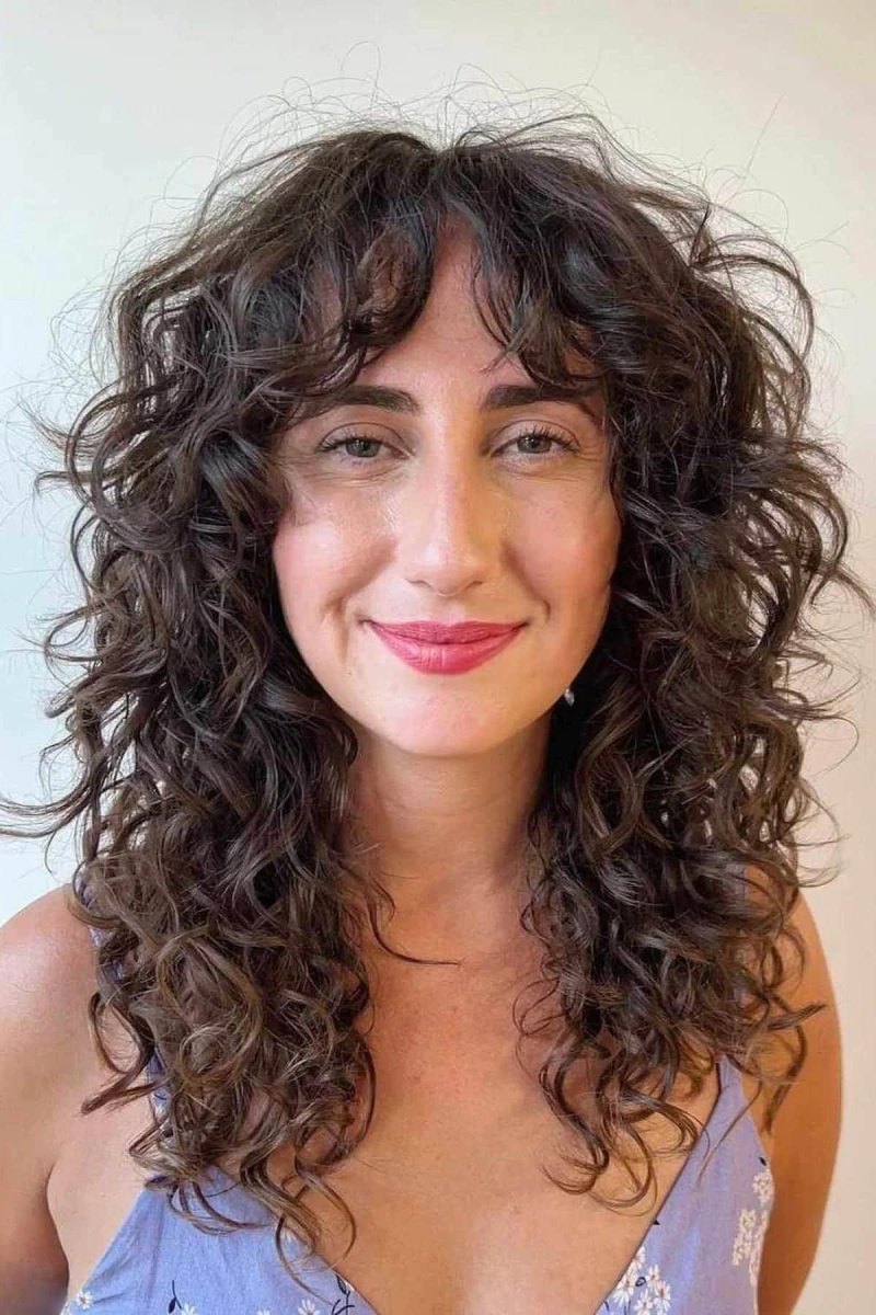 Cheveux bouclés dégradés frange rideau