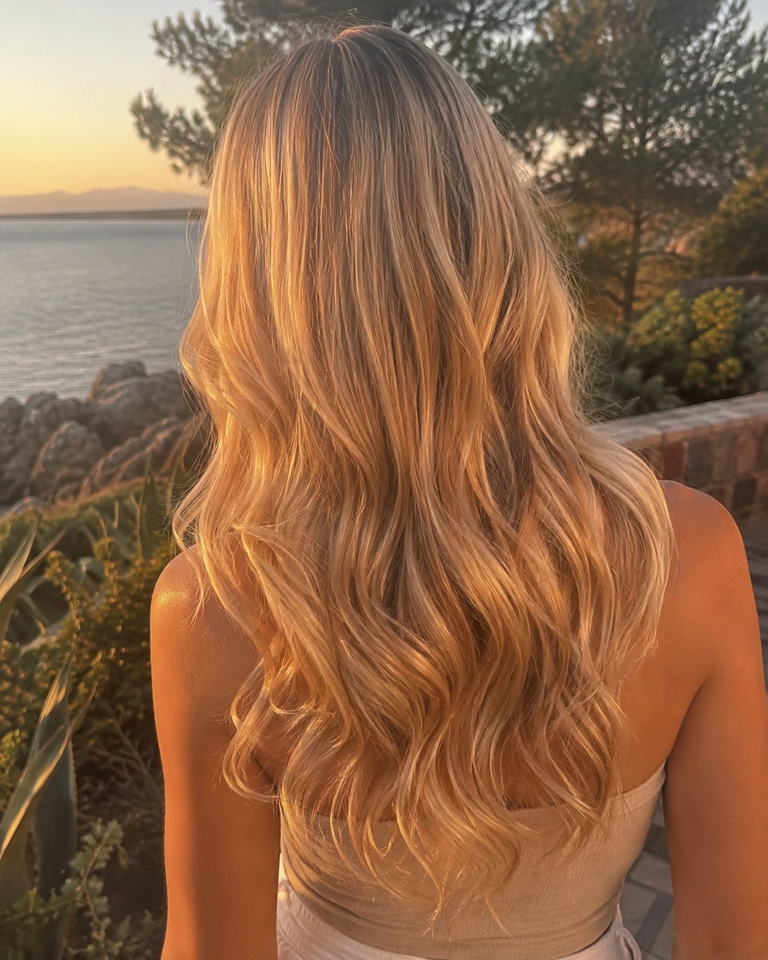 Mèches miel blond intégrales sur longueur ondulée, effet coup de soleil naturel