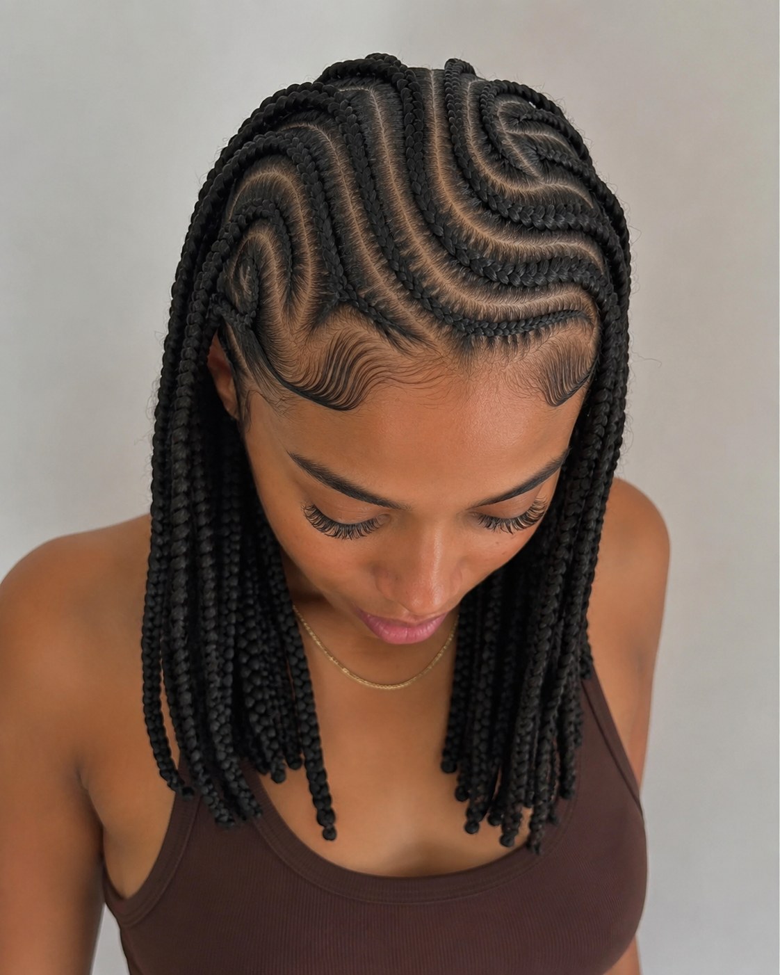 Cornrows en motif de vagues prolongées par des box braids courtes façon carré pour la rentrée
